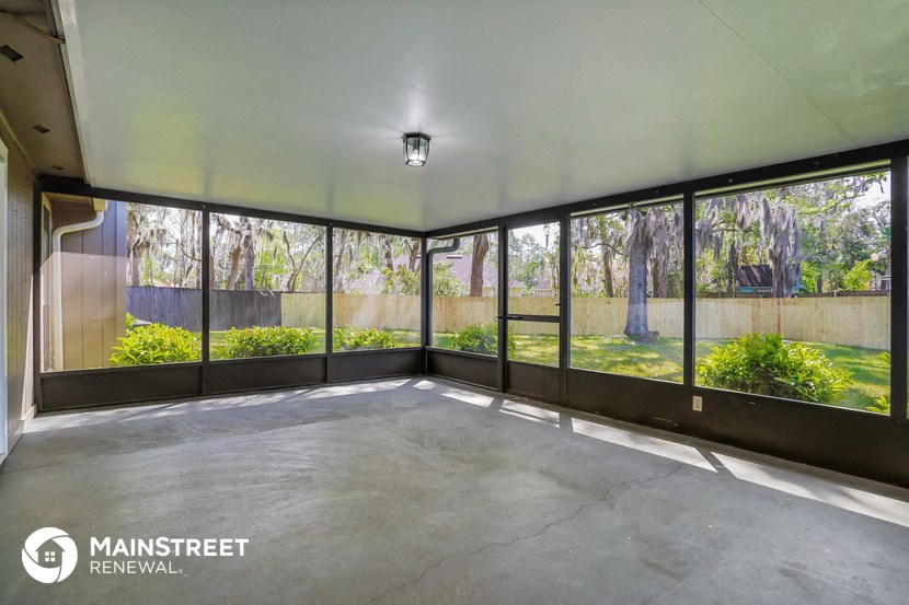 an empty room with large windows overlooking a garden