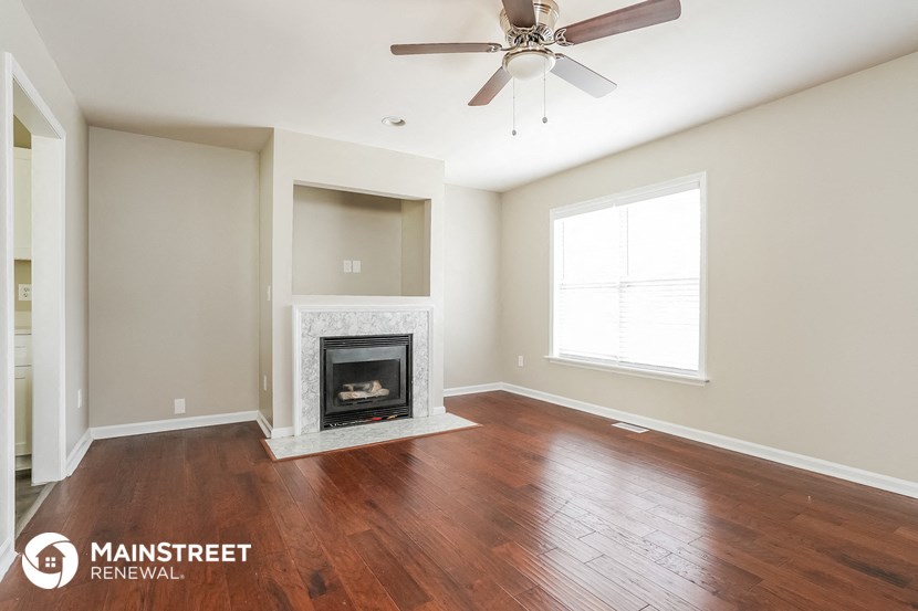 the living room with wood flooring and fireplace