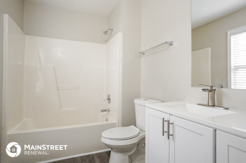 a white bathroom with a toilet and a sink