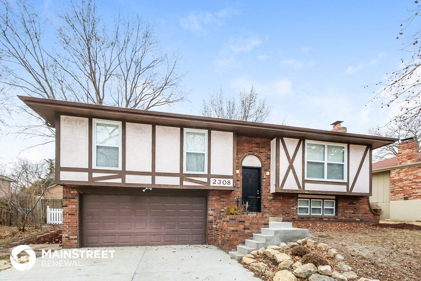 a brick house with a brown garage door