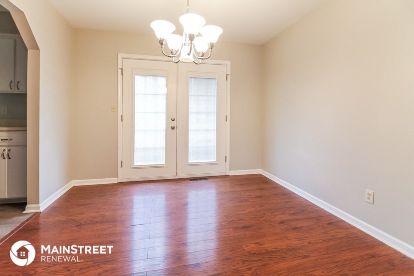 a empty living room with a wood floor and doors