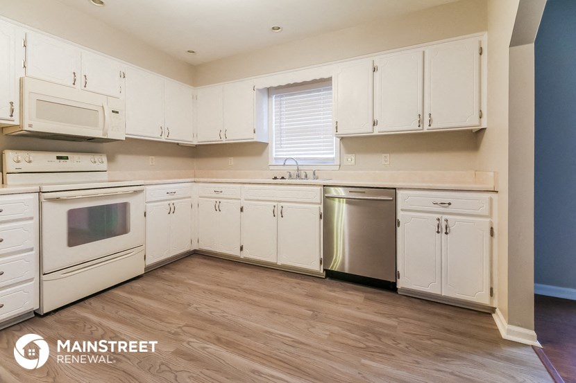 a kitchen with white cabinets and stainless steel appliances