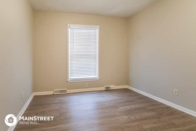 the interior of an empty room with wooden floors and a window