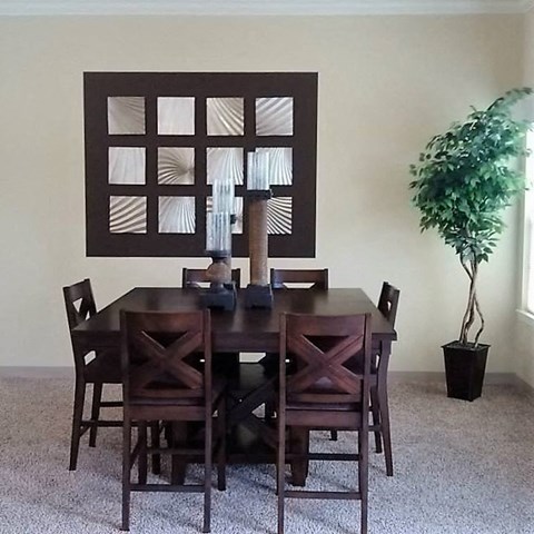a dining room with a wooden table and chairs