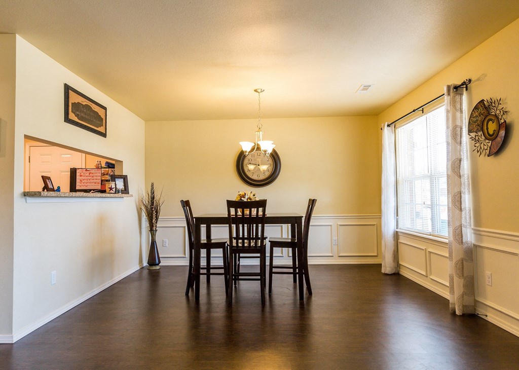 a dining room with a table and chairs and a window