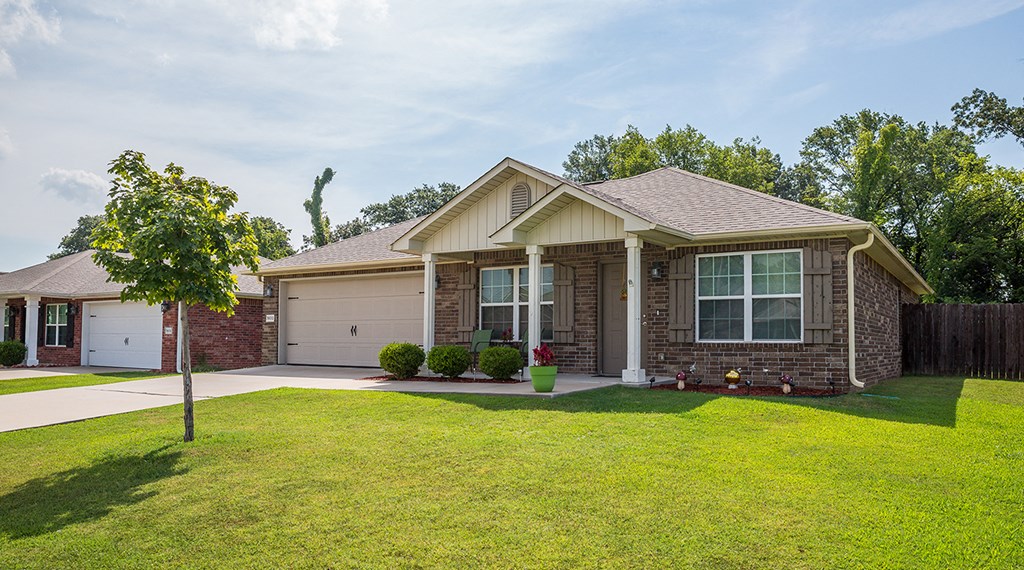 a house with a lawn and a tree in front of it