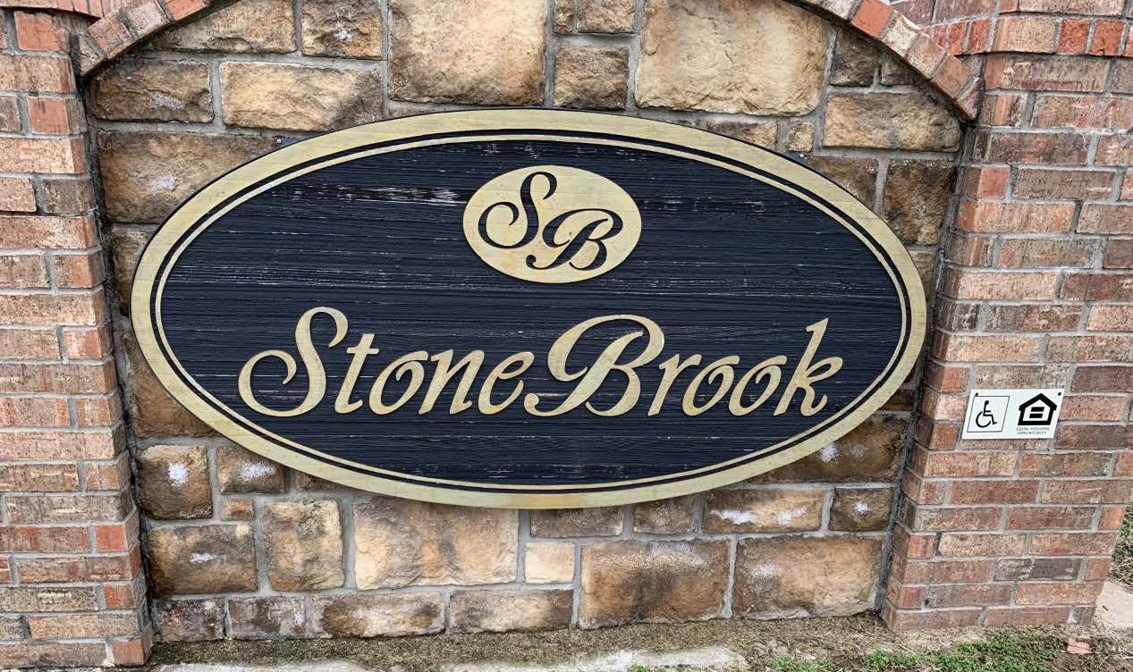 a stone brook sign on a brick wall