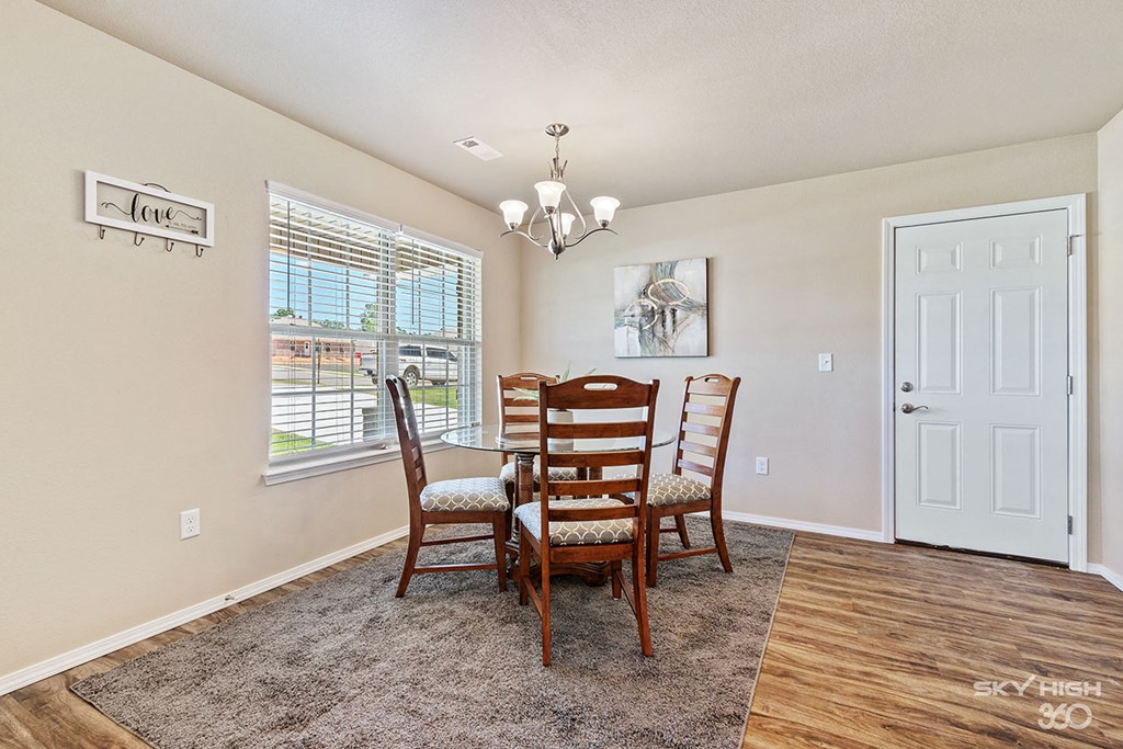 a dining room with a table and chairs and a window