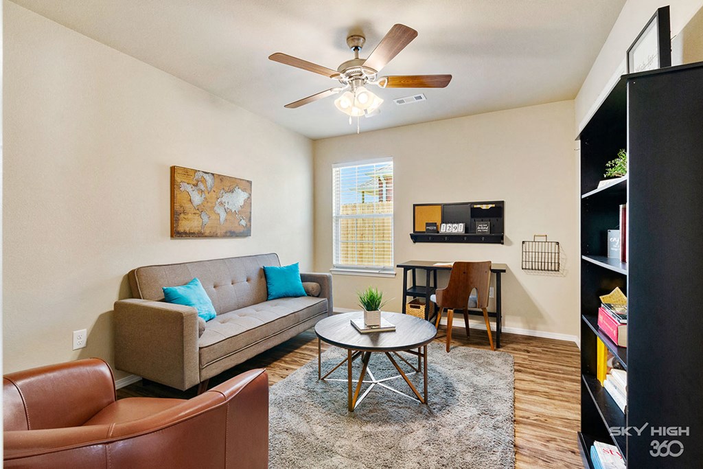 a living room with a couch and a ceiling fan