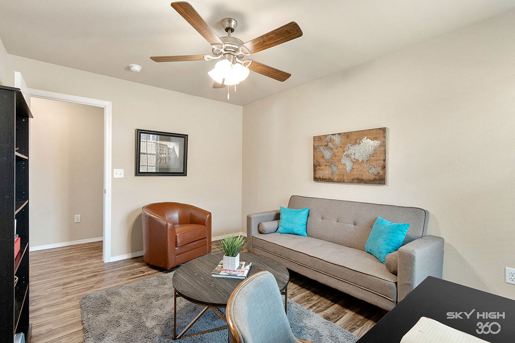 a living room with a couch and a ceiling fan