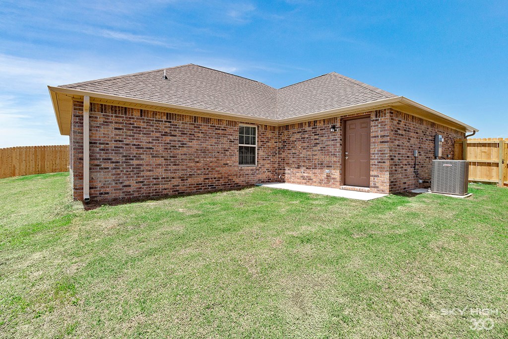 a small brick house with a yard and a backdoor
