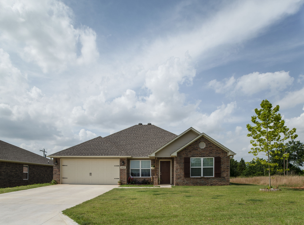 a house with a lawn and a cloudy sky