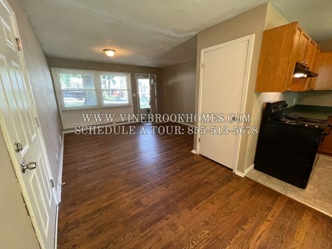 A kitchen with a black stove top oven and wooden cabinets.