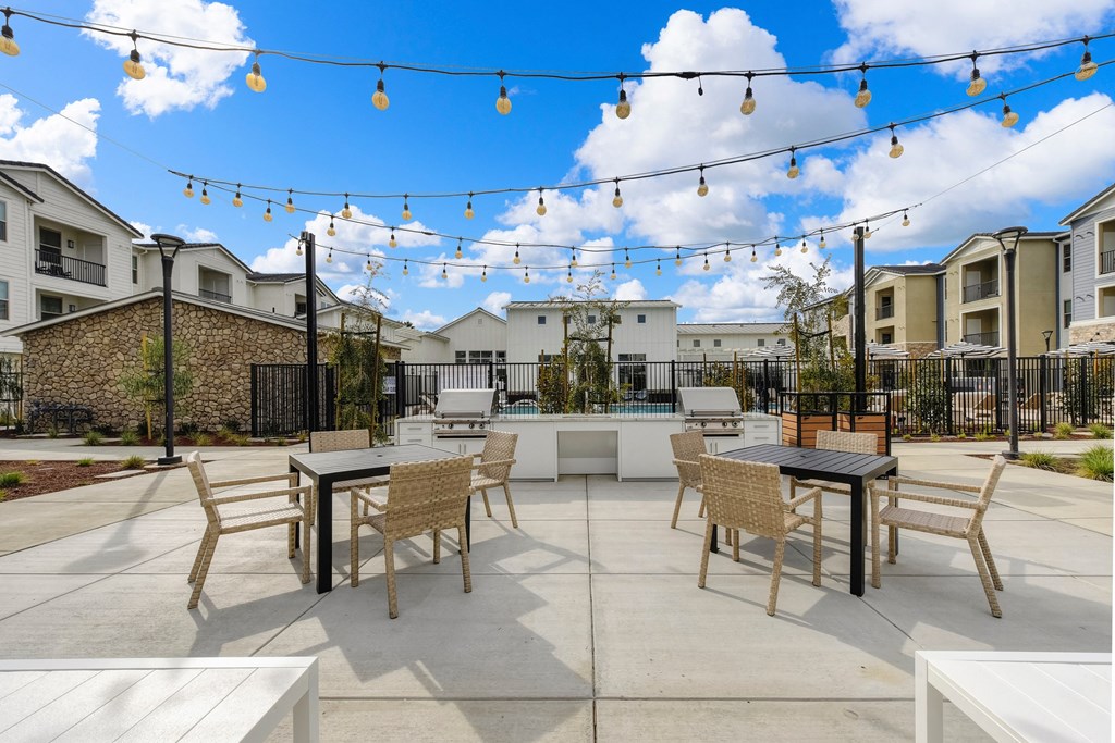 Outdoor seating area overlooking the community BBQ area, Chairs and Hanging Lights at Morgan Ranch Apartments, Morgan Hill