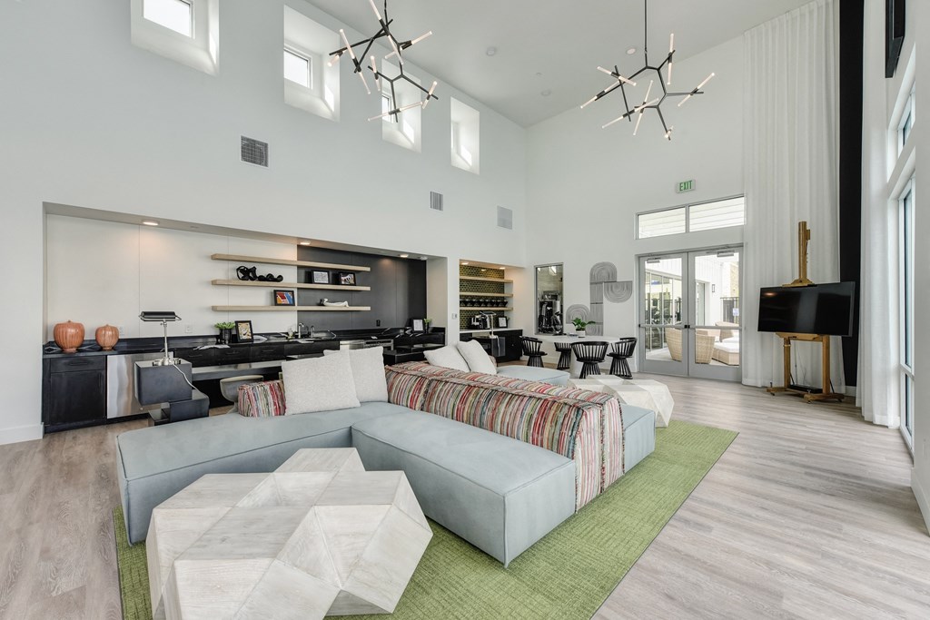 Community Clubhouse with round white table, black chairs, Hardwood Inspired Floor at Morgan Ranch Apartments, Morgan Hill, California