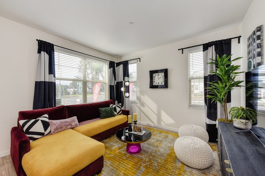 Living Room with Hardwood Inspired Flooring with Red and Yellow Couches at Morgan Ranch Apartments, Morgan Hill, CA, 95037