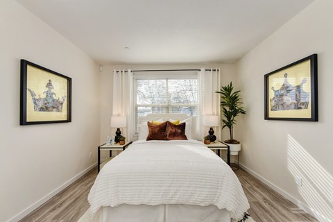 Master bedroom with large white bed positioned under the window at Morgan Ranch Apartments, Morgan Hill, 95037