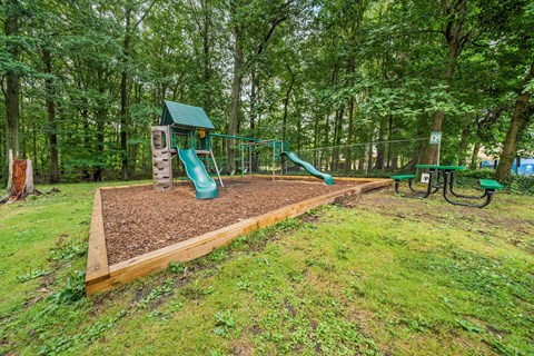 the playground is equipped with slides and picnic tables