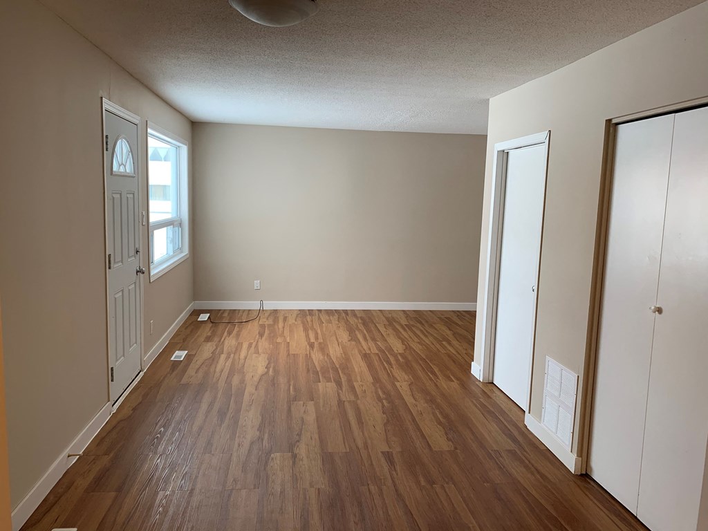 A room with wooden flooring and white walls.
