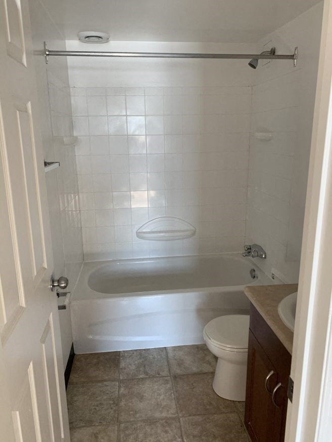 A white bathroom with a toilet, sink, and bathtub.