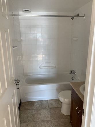 a bathroom with a toilet and a tub and a sink