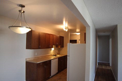 A kitchen with brown cabinets and a white refrigerator.