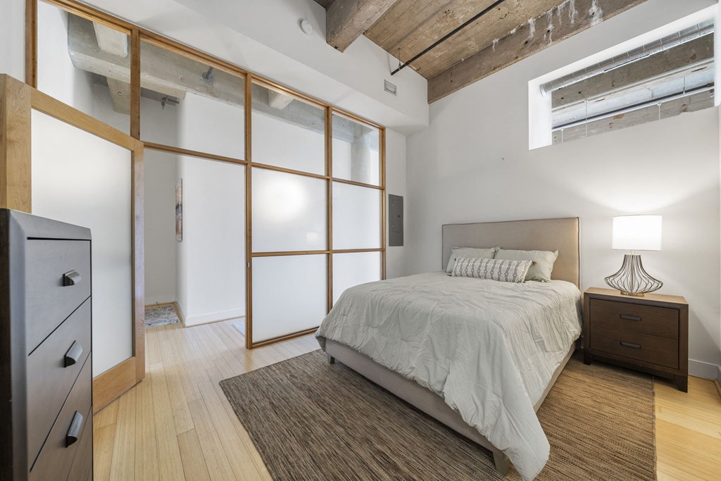 a bedroom with a bed and a large window