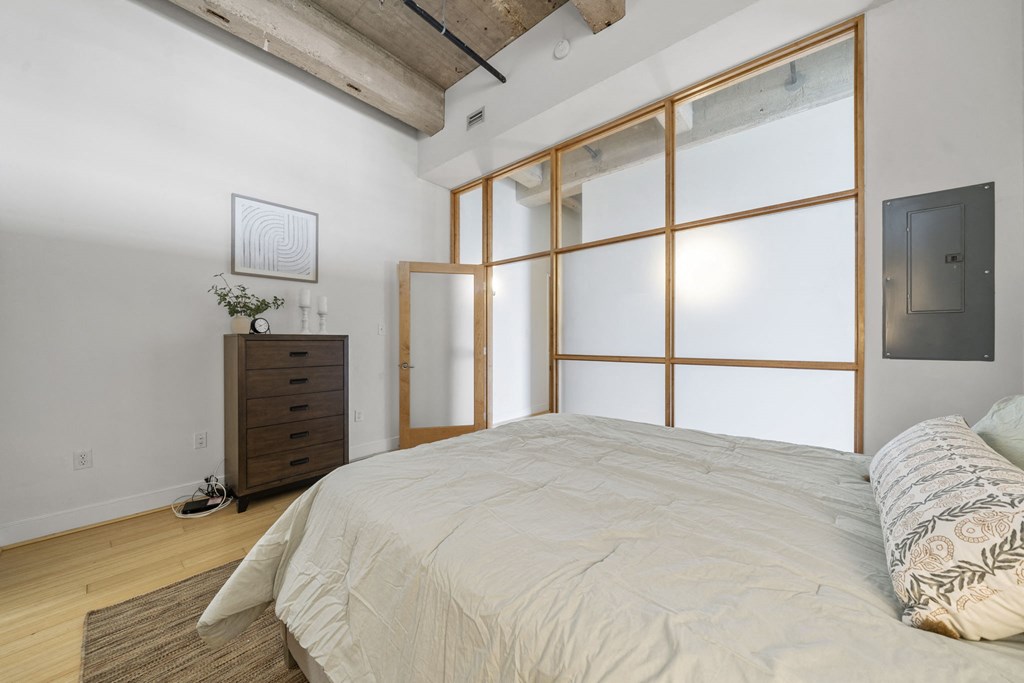 a bedroom with a bed and a large window
