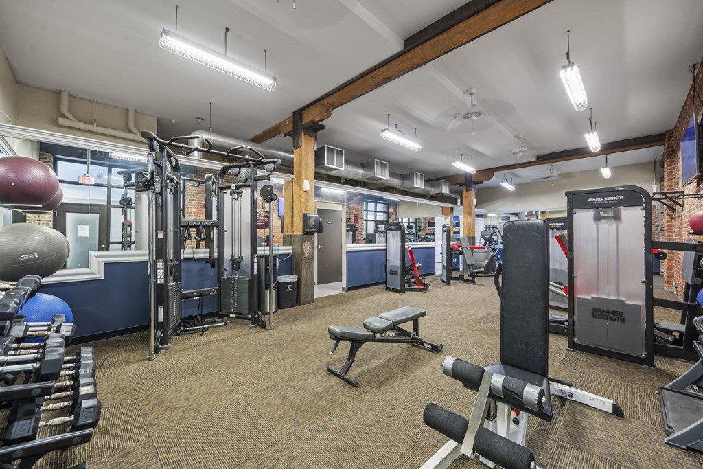 a gym with weights and other equipment in a building with brick walls