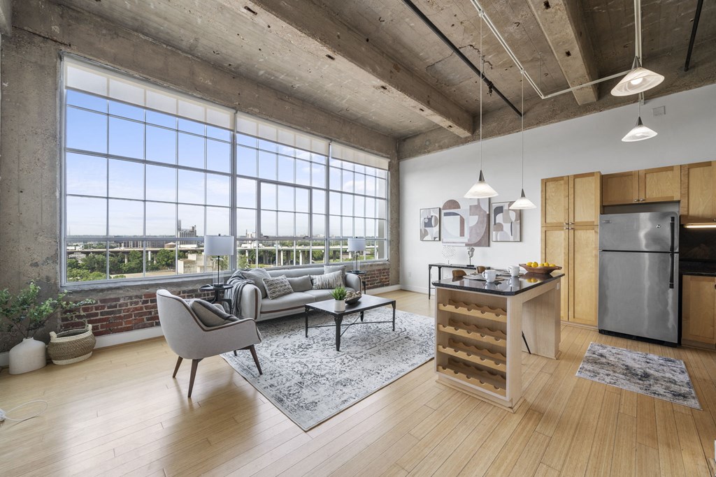 an open living room with a kitchen and a large window