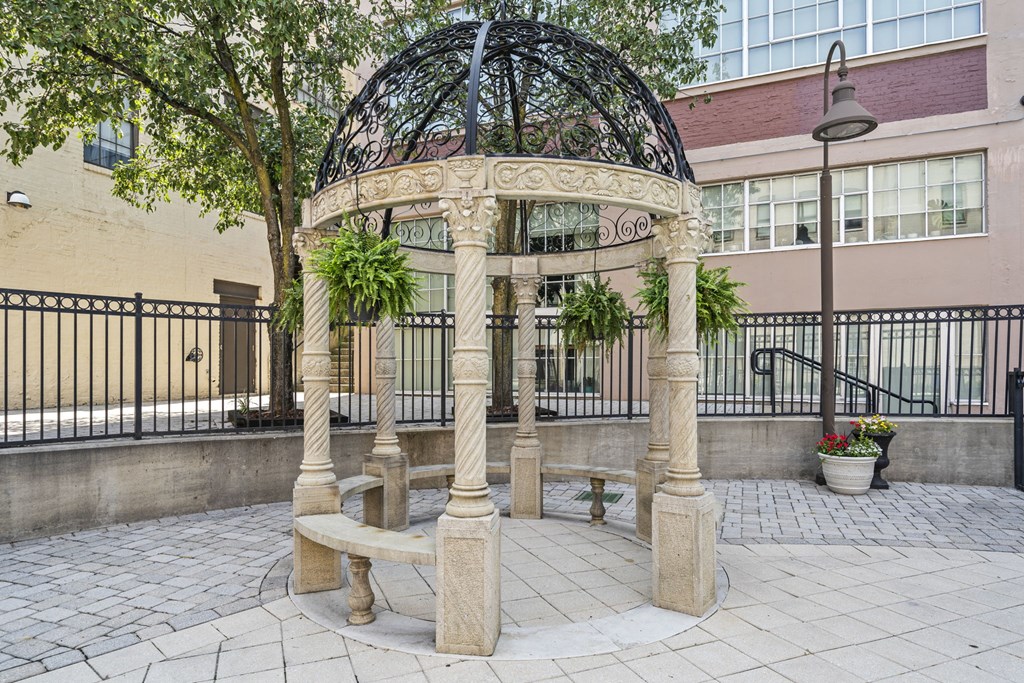 a gazebo in a courtyard with trees and a building