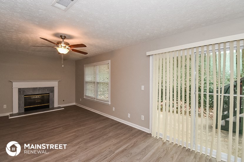 a living room with a fireplace and a ceiling fan