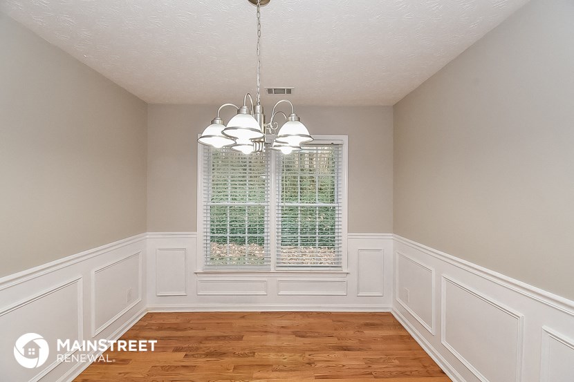 a dining room with white walls and a window