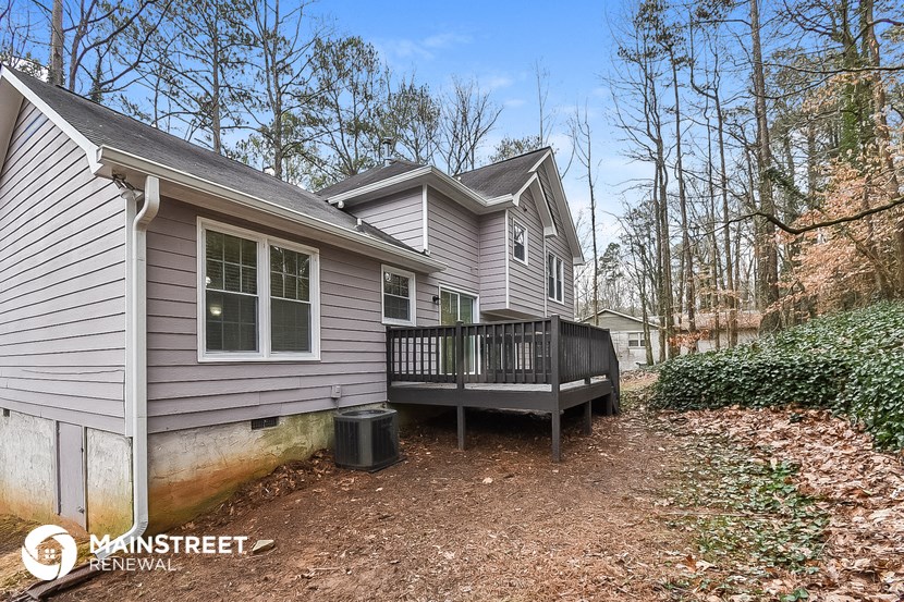 a backyard with a deck and a house with a wooden deck