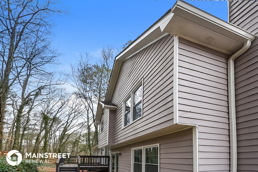 the outside of a house with gray siding and a window