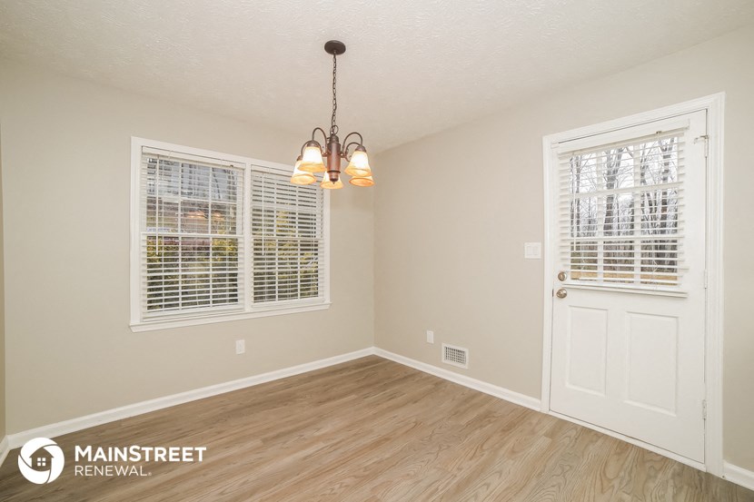 the living room of a house with a white door and window