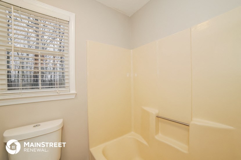 a bathroom with a toilet and a shower and a window