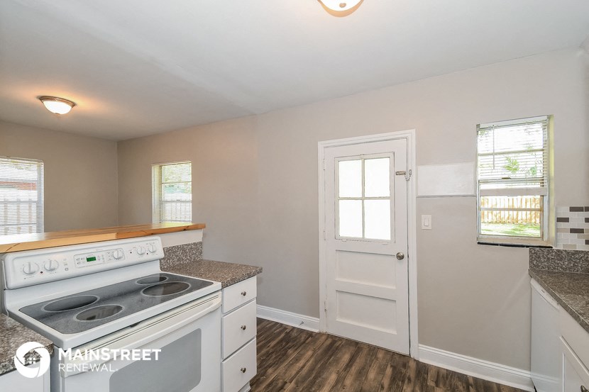 a kitchen with a stove and a white door