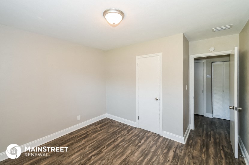 the master bedroom has a large closet and hardwood flooring