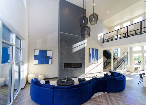 A modern living room with a blue couch and a fireplace.