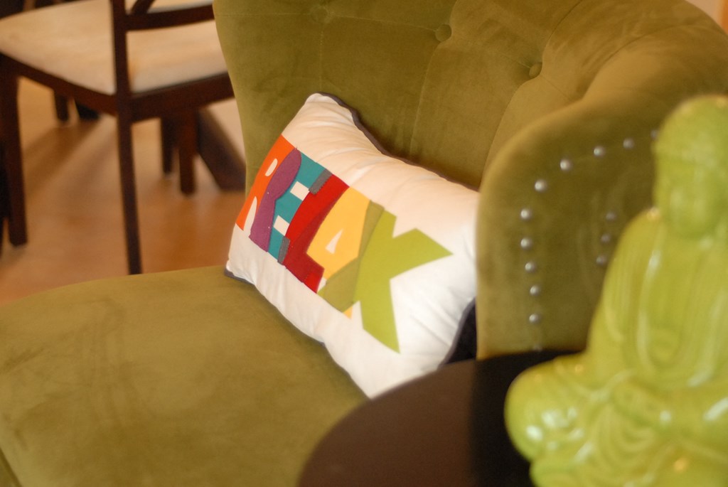 a pillow on a green chair in a living room