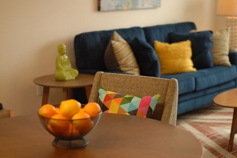 a living room with a couch and a table with oranges on it
