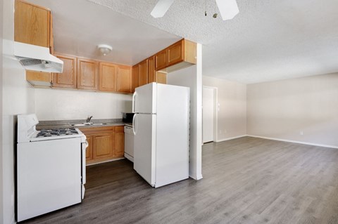A kitchen with white appliances and wooden cabinets.