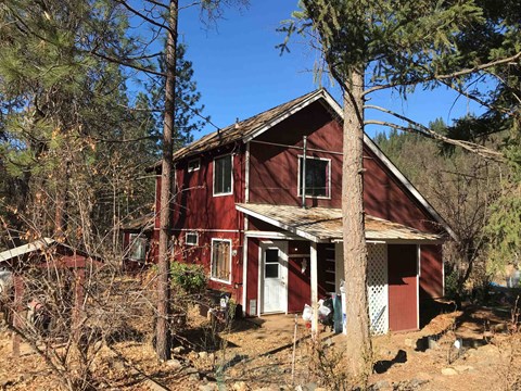a red house in the middle of the woods