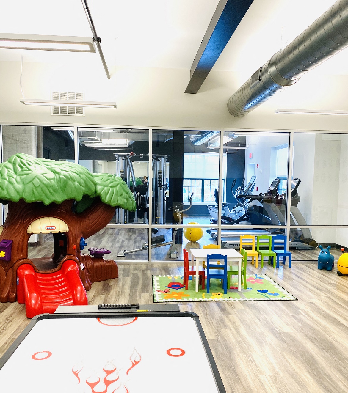 a childrens play room with a table and chairs and a toy tree