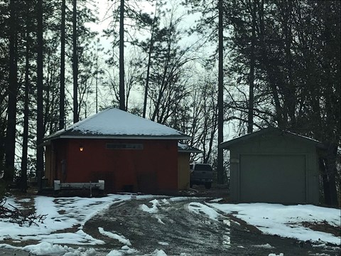 a cabin in the woods with snow on top of it