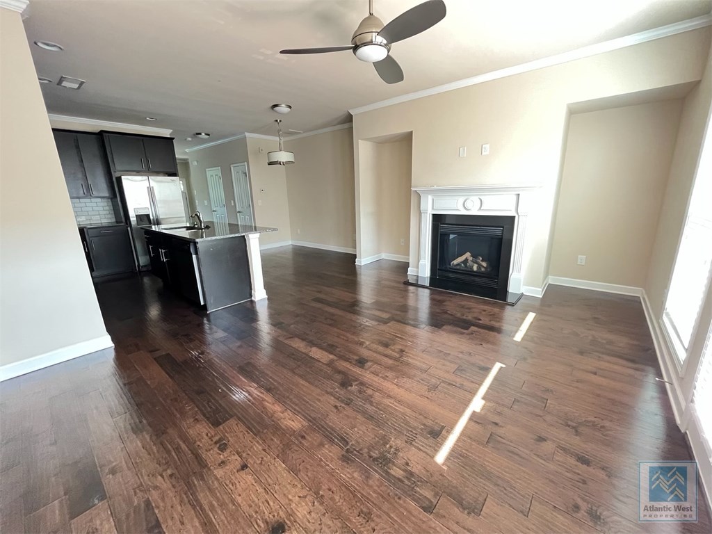 an empty living room with a fireplace and a kitchen