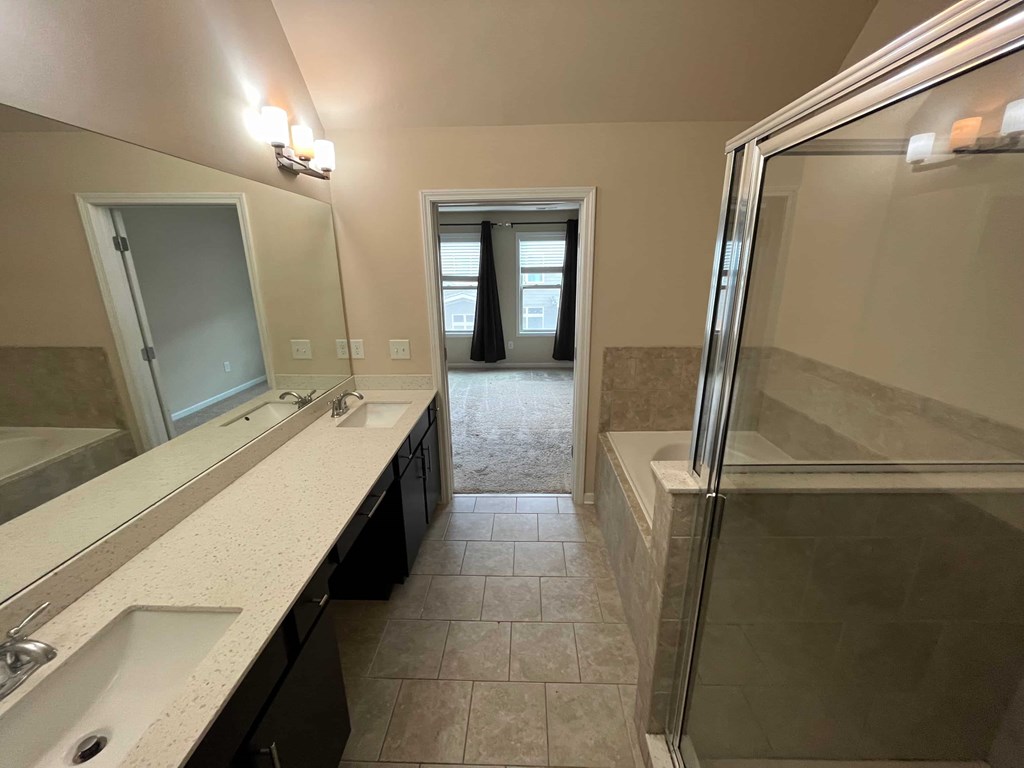 a bathroom with two sinks and a shower
