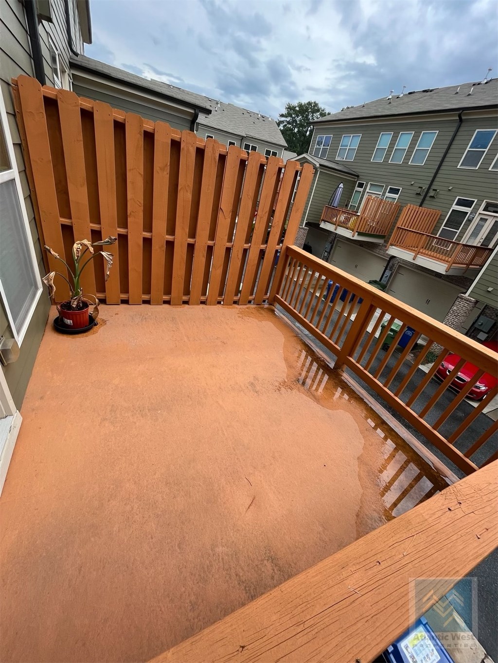 a balcony with a wooden railing and a potted plant