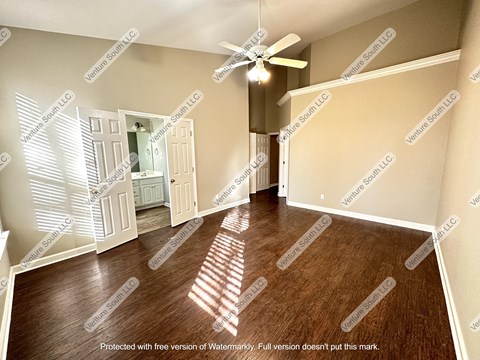 an empty living room with a ceiling fan